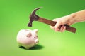 Hand with a hammer smashes a piggy bank. Money shortage concept Royalty Free Stock Photo