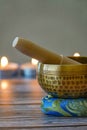 Hand-hammered Tibetan singing bowl set for meditation with candles in the background