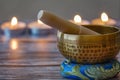 Hand-hammered Tibetan singing bowl set for meditation with candles in the background