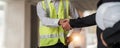 Hand in hand between project contractors and customers due to negotiation of expenses and investments, construction and Royalty Free Stock Photo