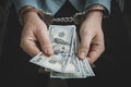 Hand with handcuffs and US dollars against dark background. concept of dependence on money. Crime in the financial Royalty Free Stock Photo