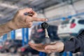 Hand handing over car keys with finger and hand receiving on gar Royalty Free Stock Photo