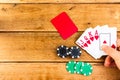 Hand having royal flush on wooden background, poker chips, dealer, gambler, poker concept