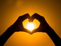 Hand heart frame shape silhouette made against sun sky of sunrise sunset Royalty Free Stock Photo