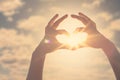 Hand heart shape silhouette made against the sun and sky of a sunrise or sunset. Royalty Free Stock Photo