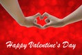 Hand on heart-shaped red background on Valentine's Day.