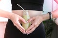 Hand in heart symbol holding smoothie drink detox on fit and slim belly woman. Fitness wellbeing concept. Body care