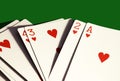 A hand of hearts only playing cards on dark green background.