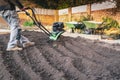 A hand held mechanical rotavator being used to reshape a garden after old turf has been removed Royalty Free Stock Photo