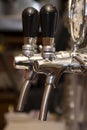 Hand-held tap pump for beer filling in the bar behind the bar, close-up, selective focus. Royalty Free Stock Photo