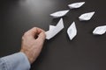 Hand of help in business concept. businessman raises fallen origami boat from white paper. Paper ships and business situation. Royalty Free Stock Photo