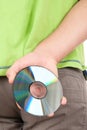 Hand hides optical disk behind bac Royalty Free Stock Photo