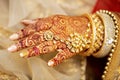 Hand of Hindu bride with henna and jewelries.