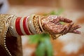 Hand of Hindu bride with henna and jewelries.