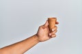 Hand of hispanic man holding biscuit cone over isolated white background Royalty Free Stock Photo