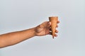 Hand of hispanic man holding biscuit cone over isolated white background Royalty Free Stock Photo