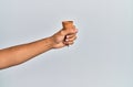 Hand of hispanic man holding biscuit cone over isolated white background Royalty Free Stock Photo