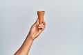 Hand of hispanic man holding biscuit cone over isolated white background Royalty Free Stock Photo