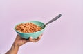 Hand of hispanic man holding bowl with italian noodles over isolated pink background Royalty Free Stock Photo