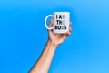 Hand of hispanic man holding i am the boss coffee cup over  blue background Royalty Free Stock Photo