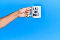 Hand of hispanic man holding i am the boss coffee cup over isolated blue background Royalty Free Stock Photo