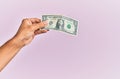 Hand of hispanic man holding one dollar banknote over isolated pink background Royalty Free Stock Photo