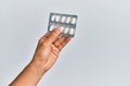 Hand of hispanic man holding pills over  white background Royalty Free Stock Photo