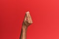 Hand of hispanic man over red isolated background doing italian gesture with fingers together, communication gesture movement Royalty Free Stock Photo
