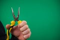 Hand hloding yellow pliers isolated advertising Green background chromakey hand pliers, And mechanic gloves.