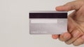 Hand is hold back of silver credit card on white background