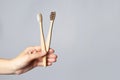 Hand hold bamboo eco tooth brush. Grey background Royalty Free Stock Photo