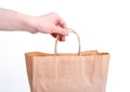 Hand hold brown kraft paper bag on white wall background Royalty Free Stock Photo