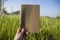 Hand hold on the brown notebook with natural light in garden outdoor at Chiang Ma,Thailand.