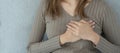 hand hold chest with heart attack symptoms, asian woman have chest pain caused by heart disease, leak, dilatation, enlarged