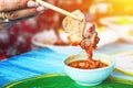 Hand hold chopsticks with pork and spicy sauce in white cup Royalty Free Stock Photo