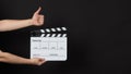 Hand is hold clapperboard or movie slate and do like hand sign.It is used in film production and cinema,movies industry on black