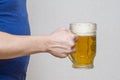 Hand hold glass mug of beer on white background. Beer in a glass holding by hand Royalty Free Stock Photo