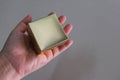 Hand hold gold square box on plain background