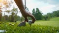 Hand hold golf ball with tee on course, golf course background Royalty Free Stock Photo