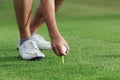 Hand hold golf ball with tee on course Royalty Free Stock Photo