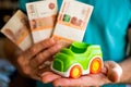 Hand hold green toy car and russian money.fixed rate for car loan, or Saving money for car, trade car for cash, finance