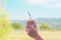Hand hold iced latte coffee in a tall glass. cold summer drink background