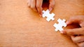 Hand holding 2 white color jigsaw and try to complete assembly Royalty Free Stock Photo