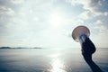 Hand hold megaphone against sea under sky