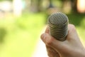 Hand hold microphone. Interview in the park. Royalty Free Stock Photo