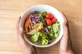 hand hold mixed Salad bowl on wooden table Royalty Free Stock Photo