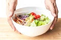 hand hold mixed Salad bowl on wooden table Royalty Free Stock Photo