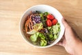 Hand hold mixed Salad bowl on wooden table Royalty Free Stock Photo