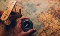 Hand hold old compass discovery and wooden plane on vintage paper antique world map Royalty Free Stock Photo