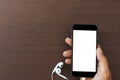 Hand hold phone white screen on wood table Royalty Free Stock Photo